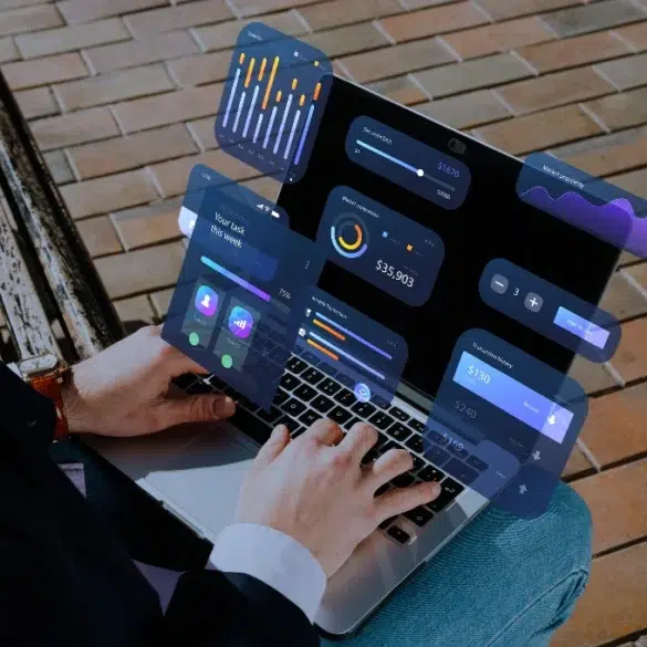 Person using a laptop with floating UI elements displaying financial data and graphs.