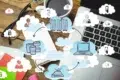 Cloud computing diagram overlays a desk with a laptop, glasses, and coffee, illustrating data storage and connectivity.