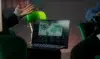 A person gestures while looking at a laptop screen displaying a world map with data visualizations.