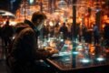 Man types on a laptop in a dimly lit, modern setting with glowing lights and out-of-focus people in the background.