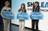 Three young women stand with signs announcing "SHELEADS LEARN, LAUNCH, LEAD" and "€60 000".