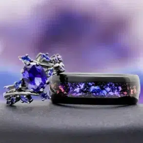 A purple gemstone engagement ring sits next to a black ring with a galaxy inlay.