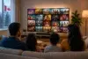 Family watching a colorful collage of television shows in a cozy living room, with popcorn, a Canadian flag visible through the window, and a potted plant beside the TV.