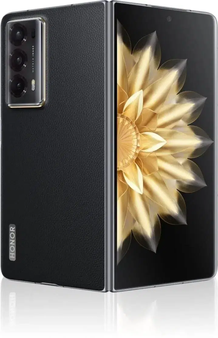 Black Honor foldable smartphone shown open, featuring a triple rear camera and a gold flower wallpaper on its inner display.