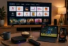 Smart TV displays live and catch-up Indian channels beside a streaming laptop showing cricket, a phone playing a movie, and a set-top box with remote, popcorn, and coffee on the table.
