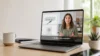 A laptop on a desk displays a woman speaking beside illustrations of a network device and speaker, with an audio waveform below.