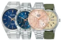 Four ALBA wristwatches are arranged side by side: two blue-dial watches, a rose-gold chronograph, and a cream-dial watch with a green fabric strap.