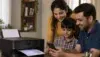 Smiling mother, father, and son gather around a smartphone beside a home printer with a document emerging, conveying family warmth and connection.