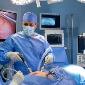 Surgeon and masked medical team perform minimally invasive surgery in a brightly lit operating room, with monitors showing the procedure; focused, clinical atmosphere.