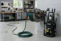all-mounted steel hose reel with a pressure washer hose partly pulled out.