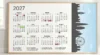 Framed 2027 wall calendar displays all twelve months and color-marked holidays beside a black London skyline with Big Ben and the London Eye.